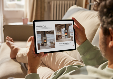 Sitzender Mann auf dem Sofa blättert online auf dem Ipad im Attika Katalog