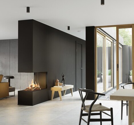 Gas-Kamin VISIO 90 RD passt als Raumteiler in einer schwarzen Wand ideal zwischen Wohnzimmer und Esszimmer und strukturiert den schlicht dekorierten Wohnraum