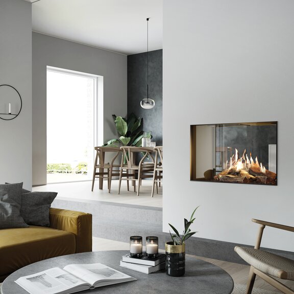 Gas-Kamin VISIO 90 T steht mitten im hell möblierten Raum und ermöglicht als Tunnel trotzdem den Durchblick von Wohnzimmer zu Esszimmer und Küche