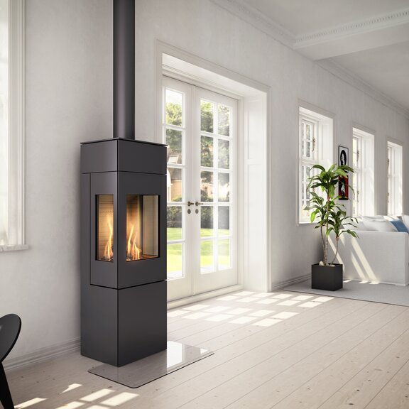 Gas-Kaminofen NEXO 140 in Schwarz mit Stahltür und zwei Seitenfenster in hellem Wohnraum