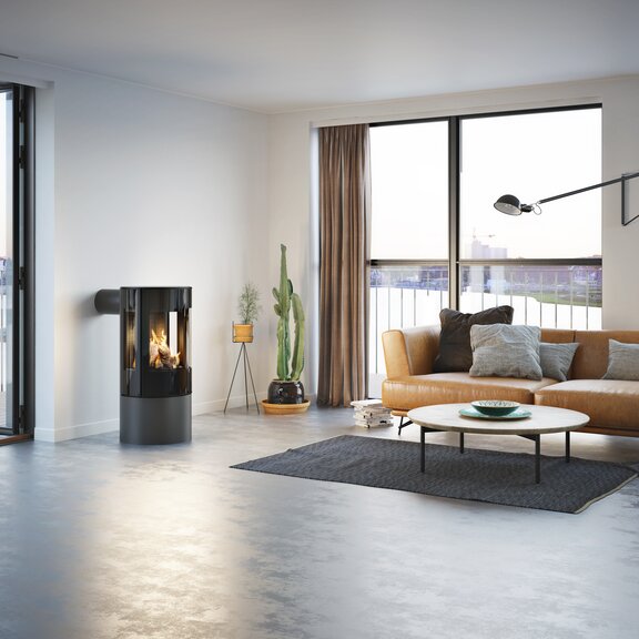 Gas-Kaminofen VIVA 100 L in Platin mit Vollglas-Feuerraumtür in einer minimalistischer Wohnung mit Aussicht auf die Skyline