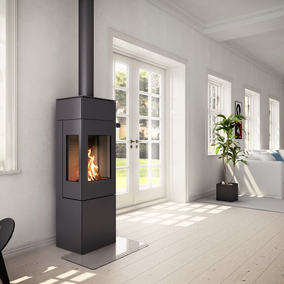 Holz-Kaminofen NEXO 140 in Schwarz mit Stahltür und zwei Seitenfenster in hellem Wohnraum