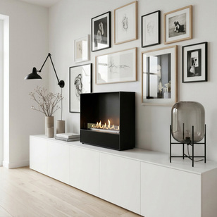 Bioethanol Feuerstelle Milan mit schwarzer Frontblende freistehend auf einem weissen Sideboard vor einer Bilderwand